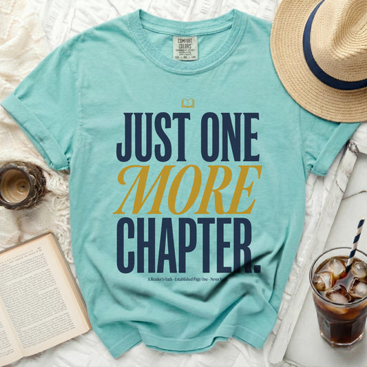 Teal t-shirt with "JUST ONE MORE CHAPTER" text and an open book.