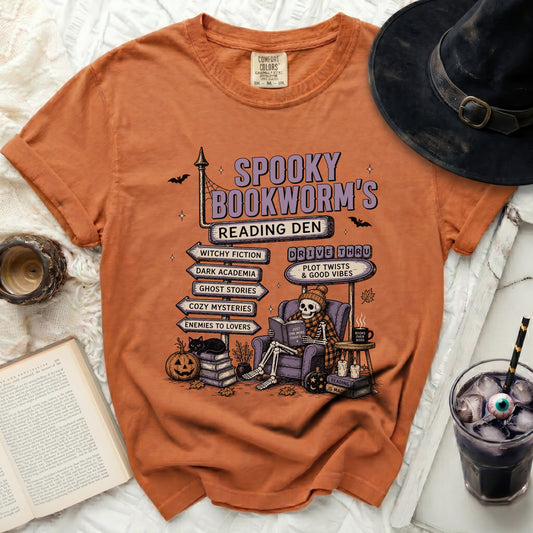 Orange t-shirt with "Spooky Bookworm's Reading Den" graphic, skeleton reading.