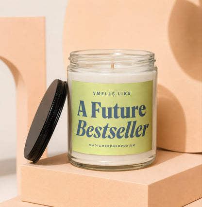 Glass jar candle with green label reading "Smells Like A Future Bestseller" and "MAGICMERCH}\EMPORIUM."