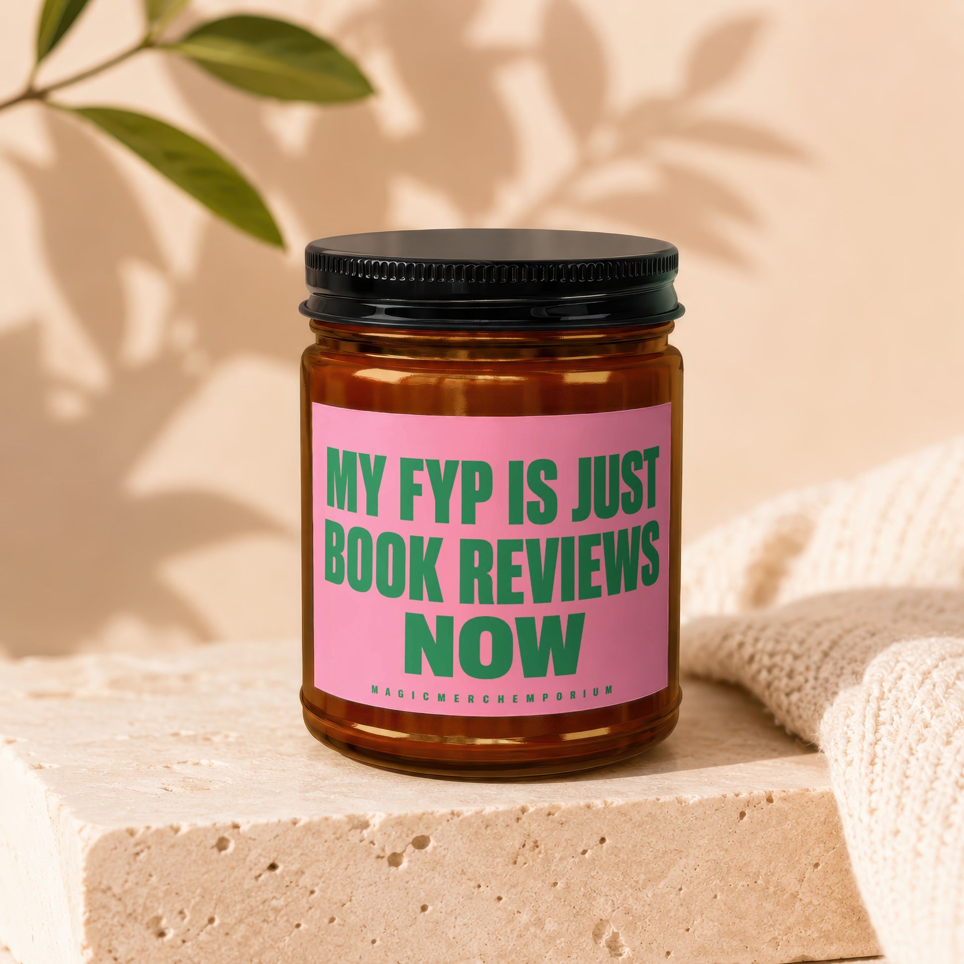 Amber jar candle with pink label reading "MY FYP IS JUST BOOK REVIEWS NOW".