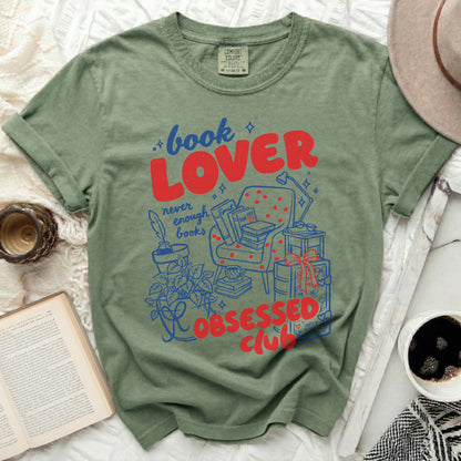 Green t-shirt with "book LOVER never enough books OBSESSED club" graphic.