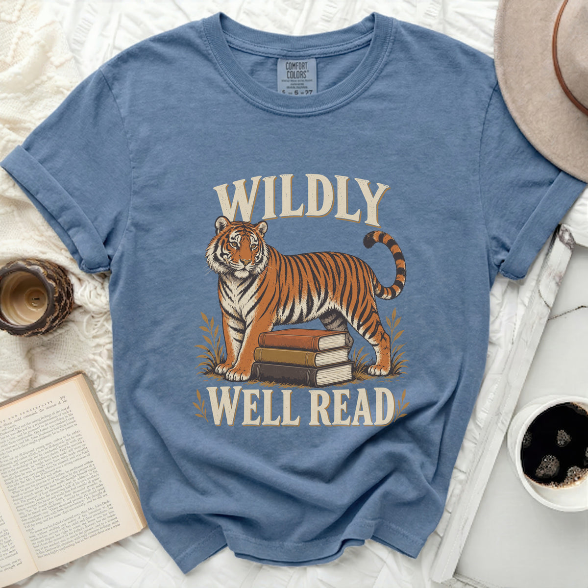Blue t-shirt with tiger graphic and text "WILDLY WELL READ".