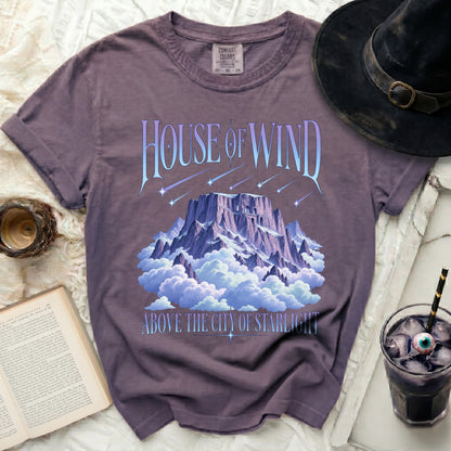 Purple t-shirt with "House of Wind Above the City of Starlight" text and mountain graphic.