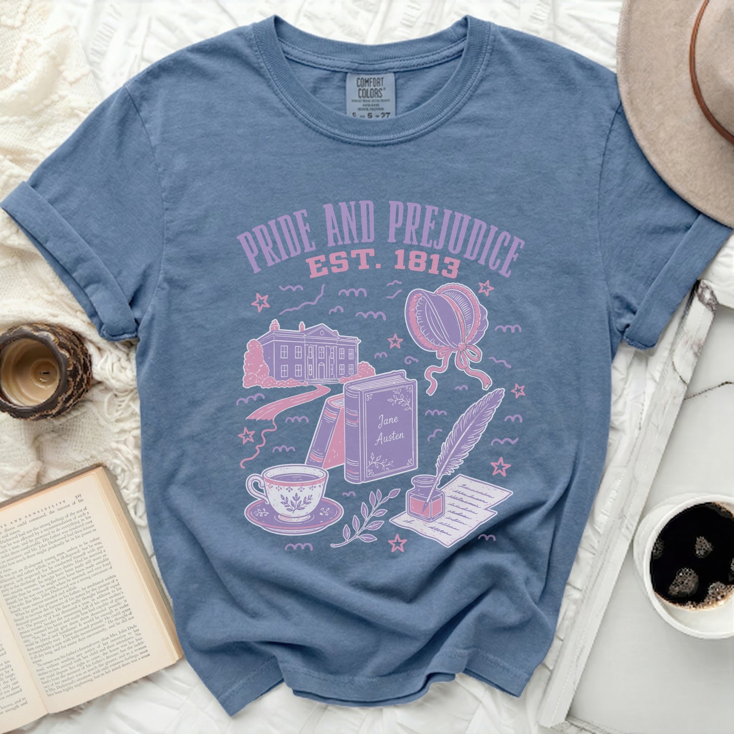 "Pride and Prejudice" t-shirt with illustrations of books, tea cup, quill, and building.