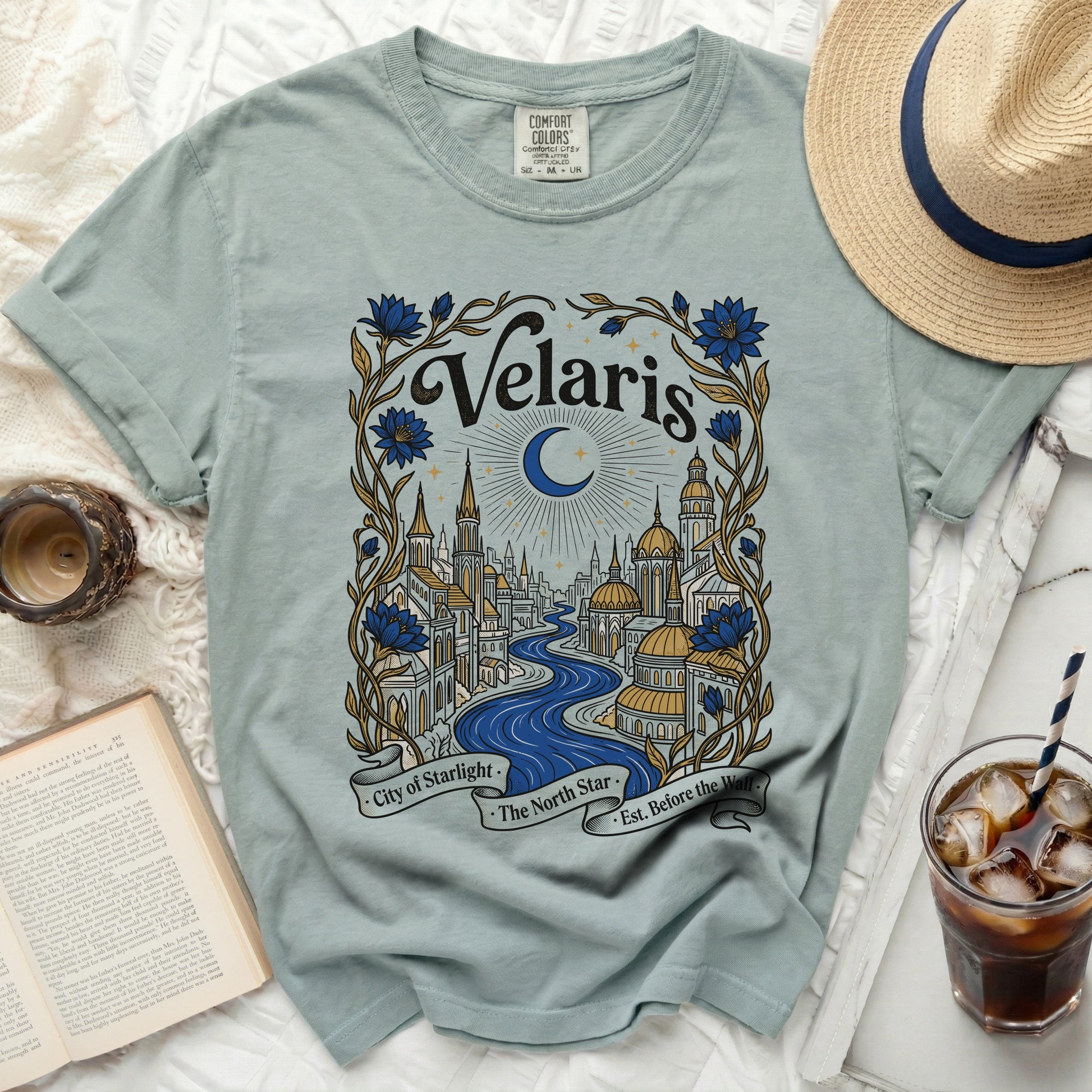 Light blue t-shirt with "Velaris City of Starlight The North Star Est. Before the Wall" graphic.