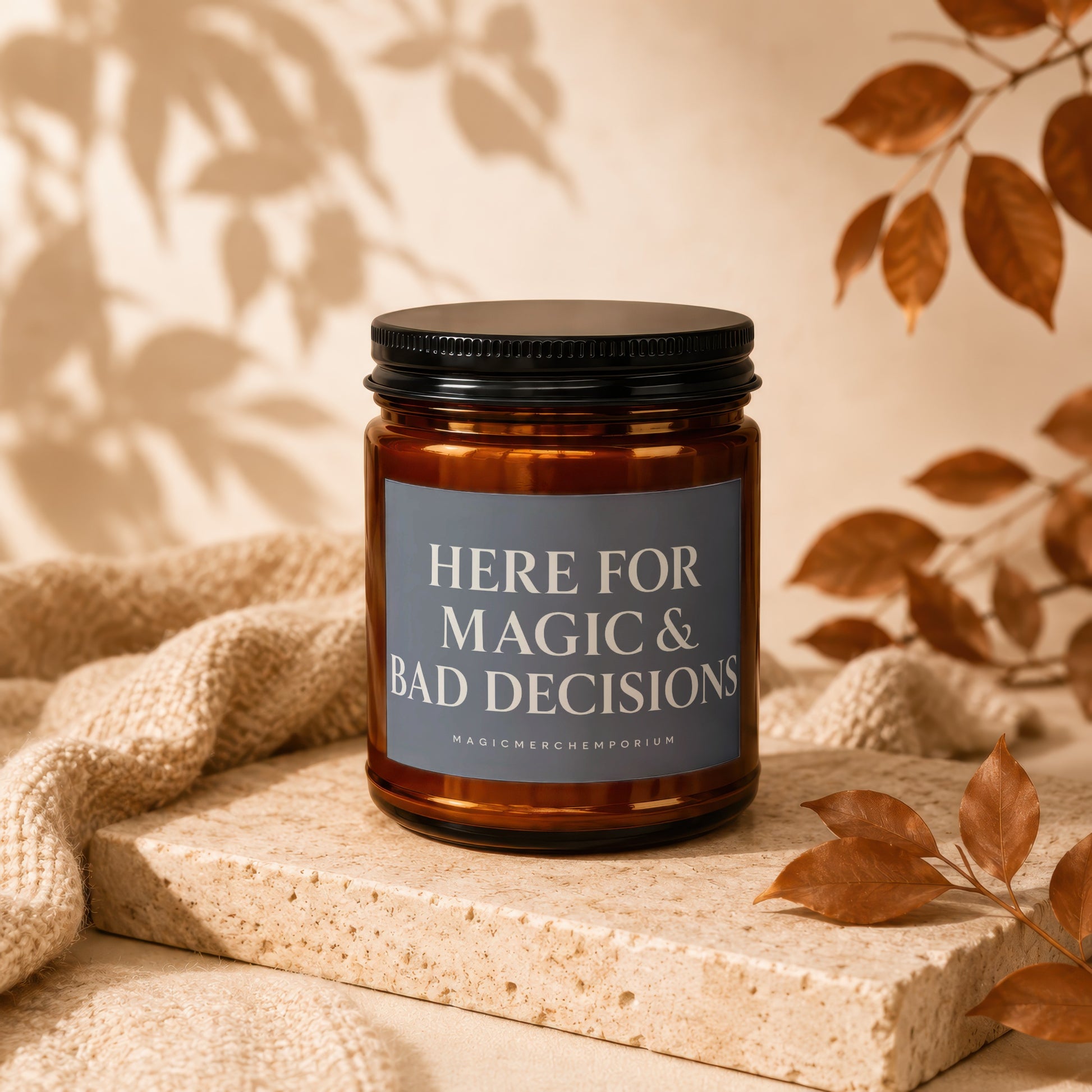 Amber candle with black lid labeled "HERE FOR MAGIC & BAD DECISIONS".