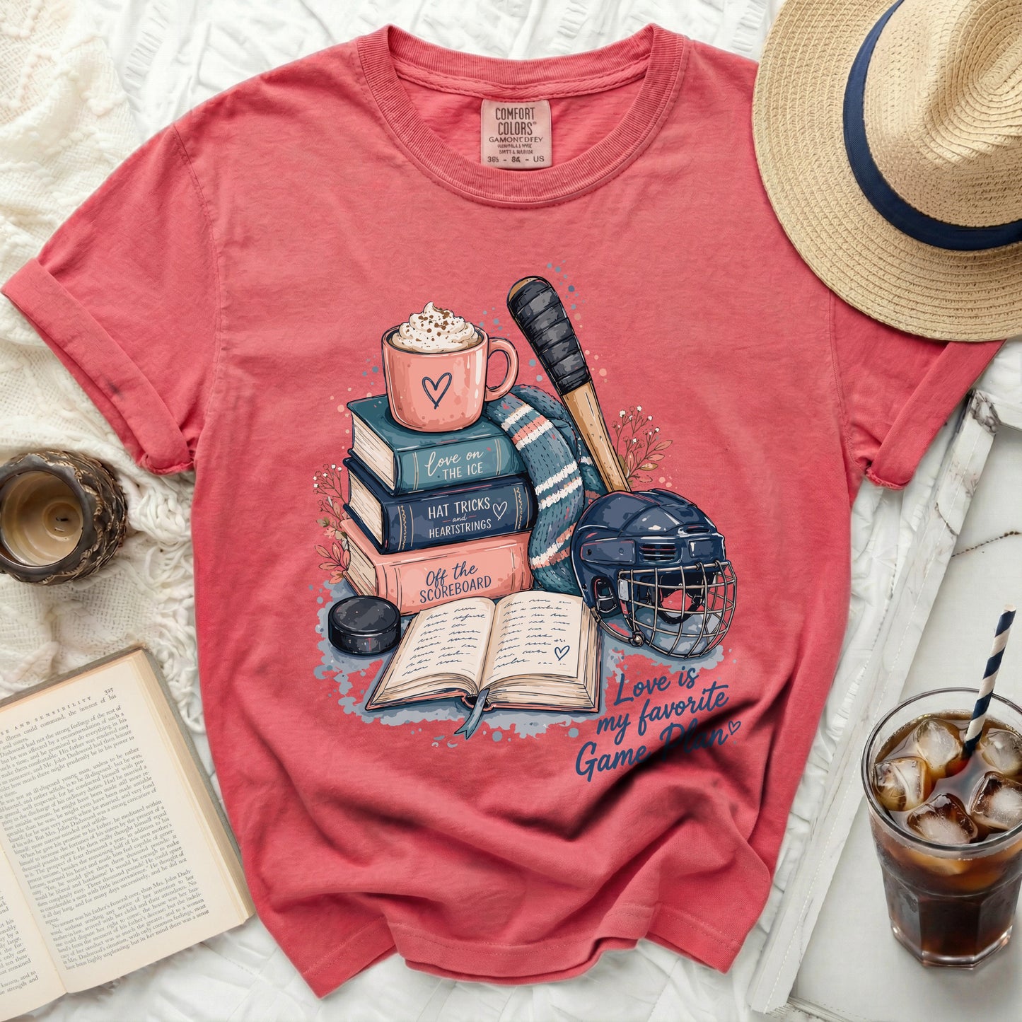 Coral t-shirt with ice hockey theme graphic and book illustrations.