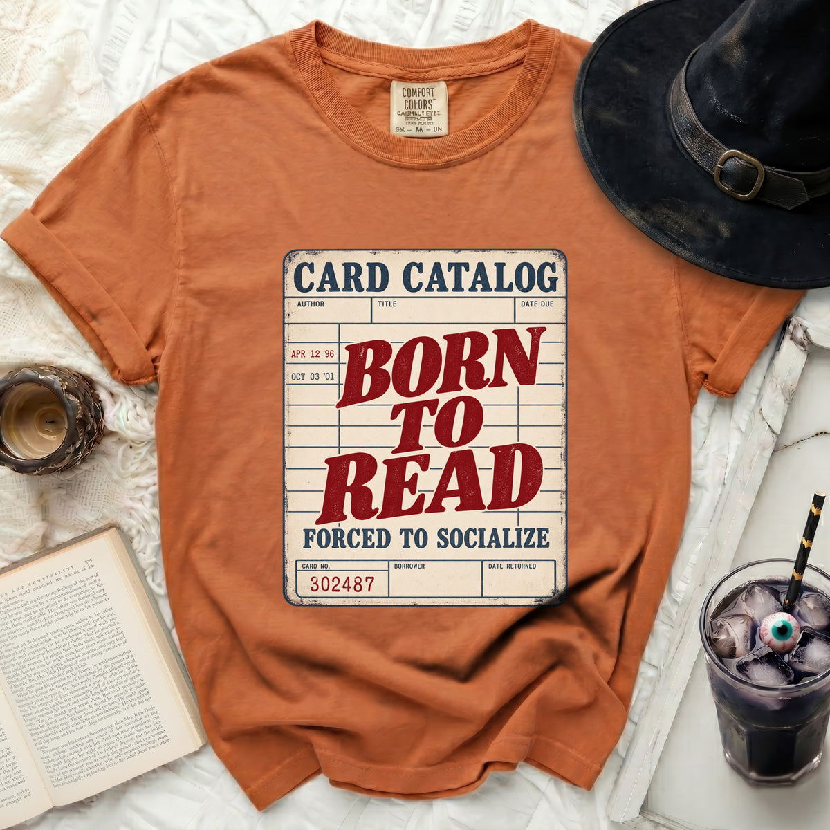 Orange t-shirt with "Card Catalog Born to Read Forced to Socialize" graphic.