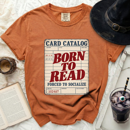 Orange t-shirt with "Card Catalog Born to Read Forced to Socialize" graphic.