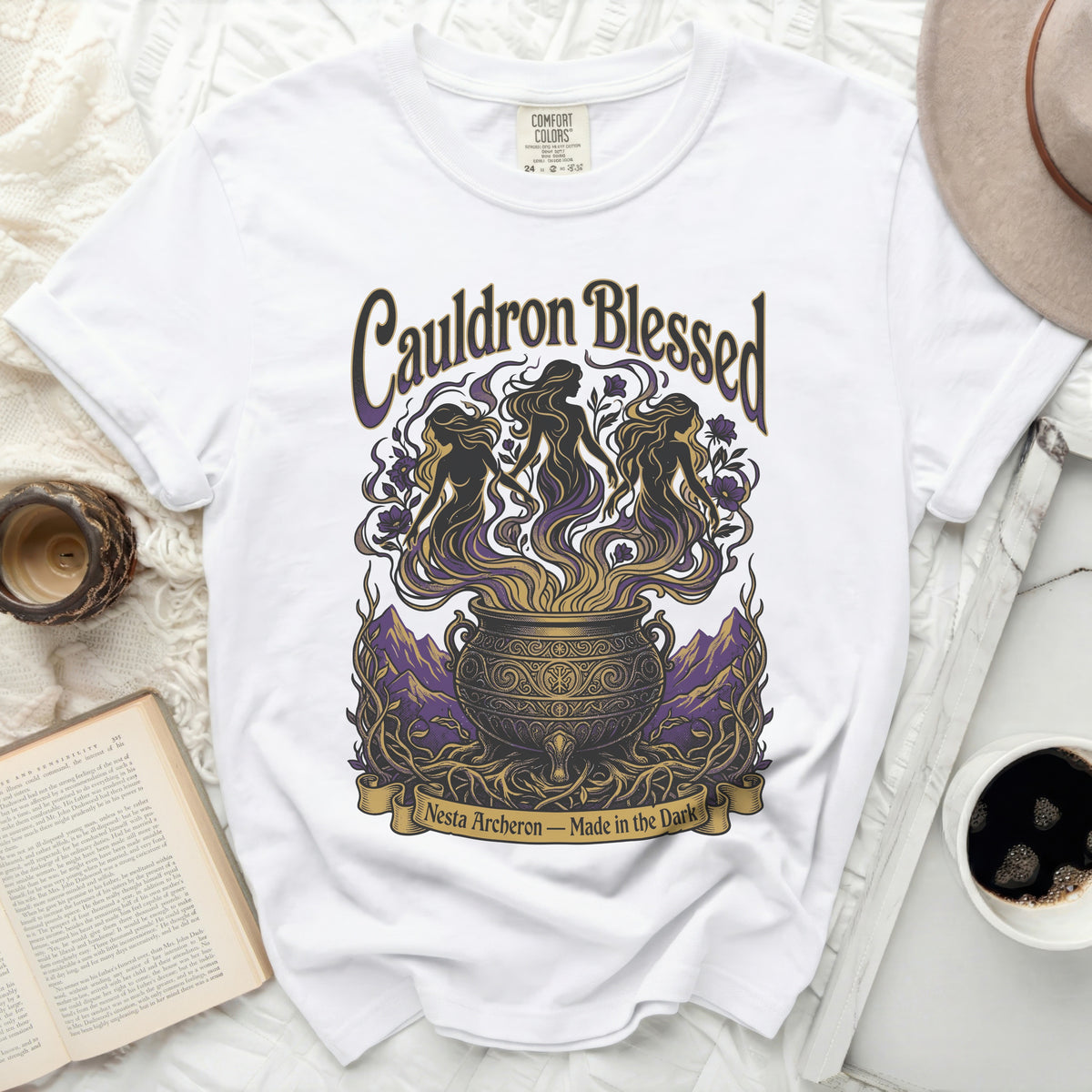 White t-shirt with "Cauldron Blessed Nesta Archeron - Made in the Dark" graphic.