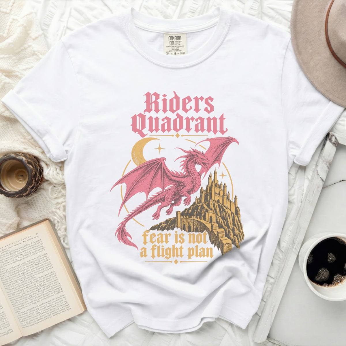 White t-shirt with pink dragon, castle, moon, and text "Riders Quadrant" and "fear is not a flight plan".