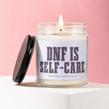 Glass jar candle with lit wick and black lid, reads "DNF IS SELF-CARE".