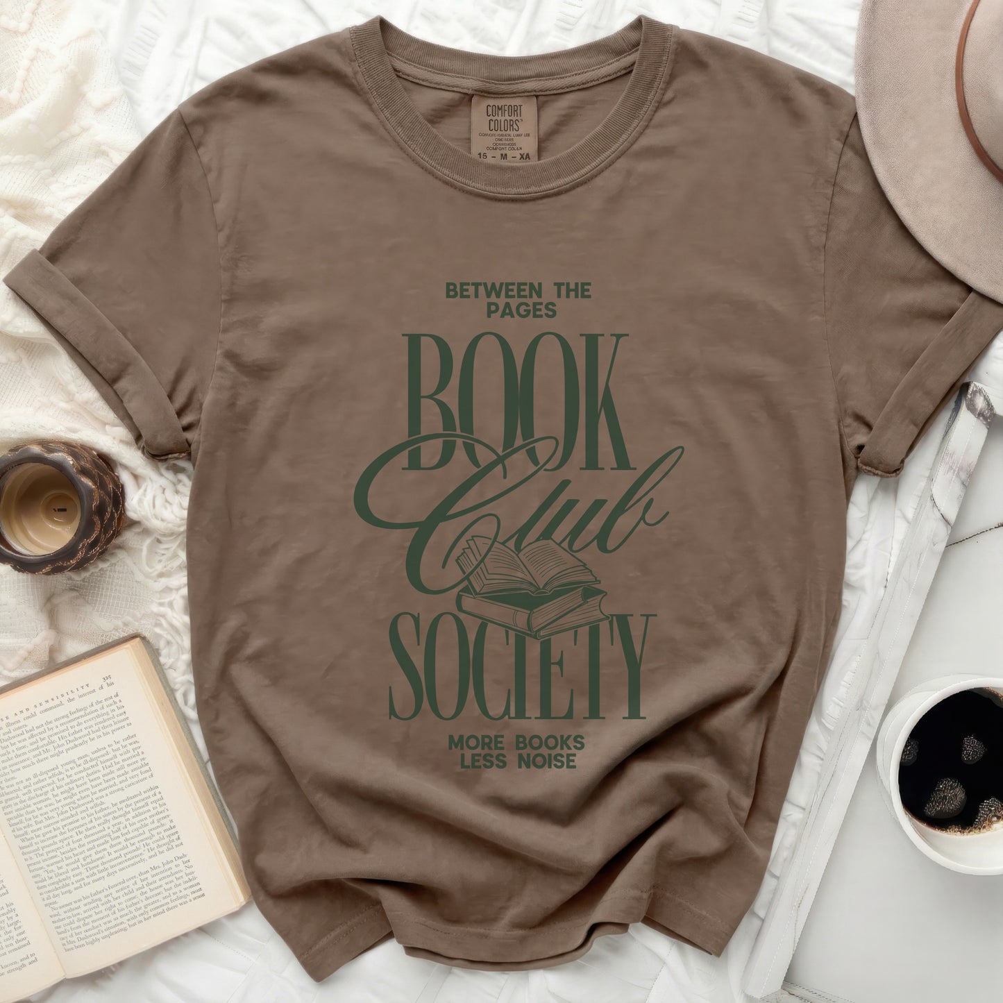 Brown t-shirt with "Between the Pages Book Club Society" graphic.
