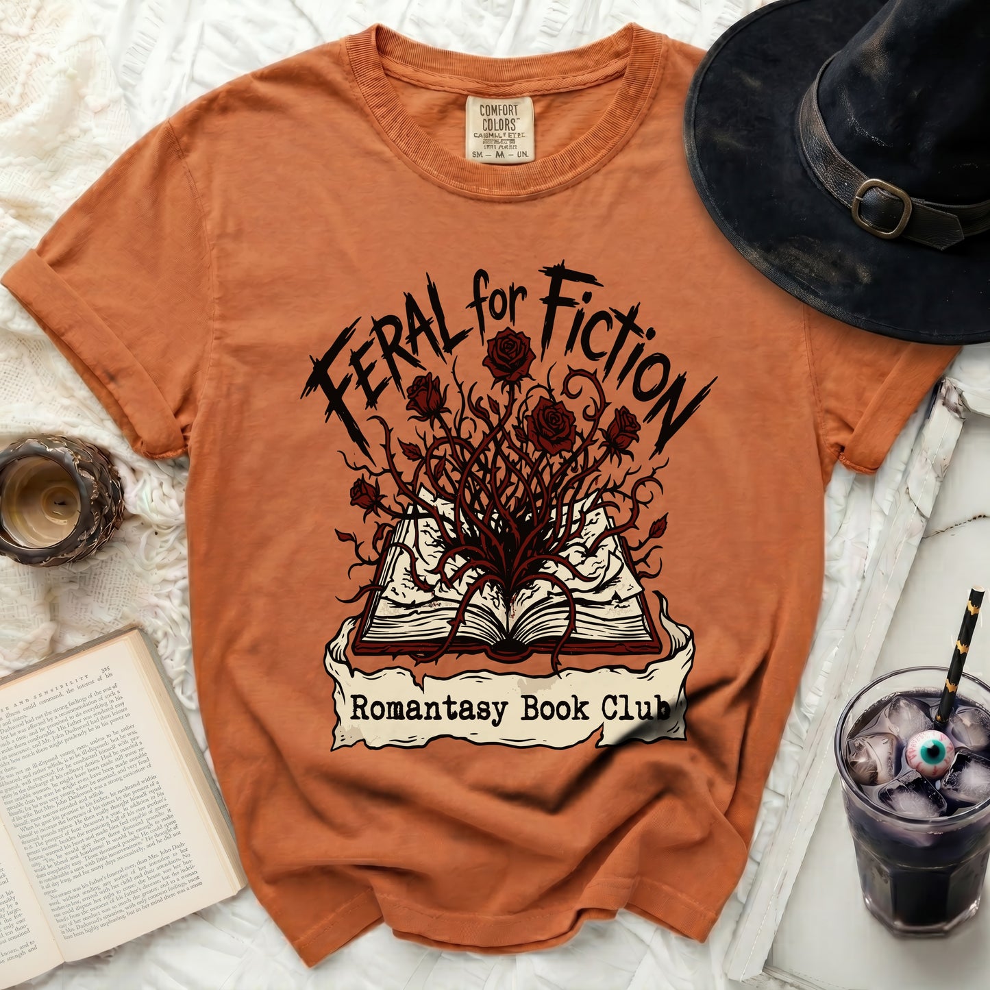 Orange t-shirt with "Feral for Fiction Romantasy Book Club" graphic.