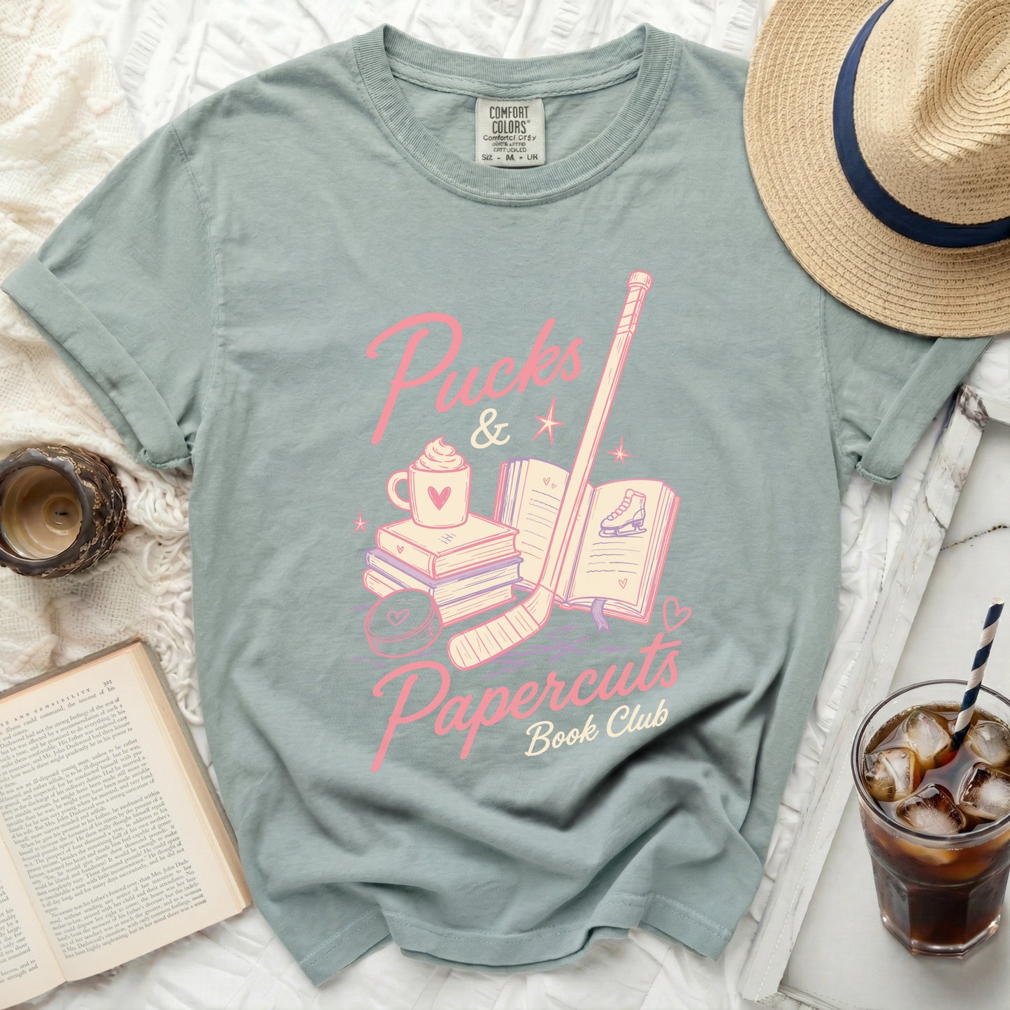 Pink ice skates, books, and coffee cup with "Puck & Papercuts Book Club" text.