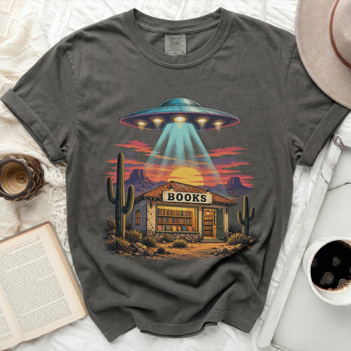 UFO abducting a bookshop in a desert landscape under a sunset.