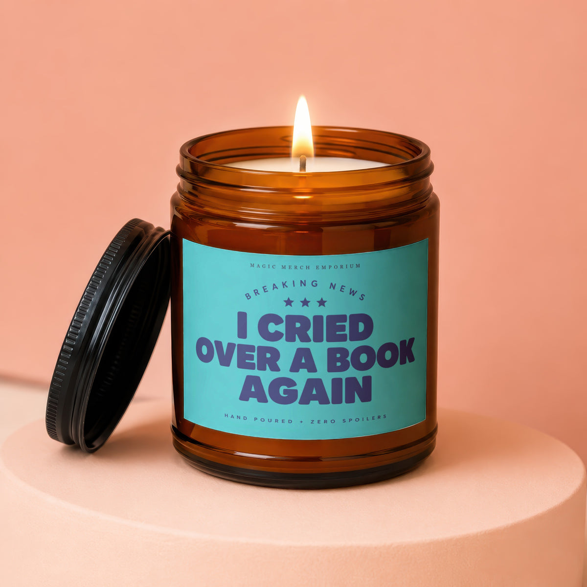 Amber glass candle with lid off, reads "I Cried Over a Book Again".