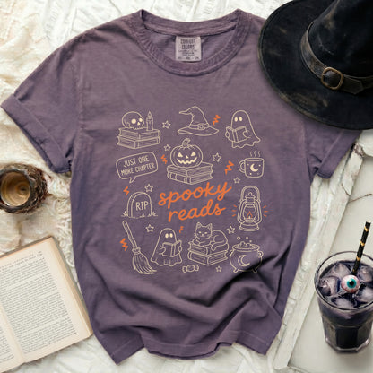 Purple t-shirt with "Spooky Reads" and Halloween-themed line drawings.