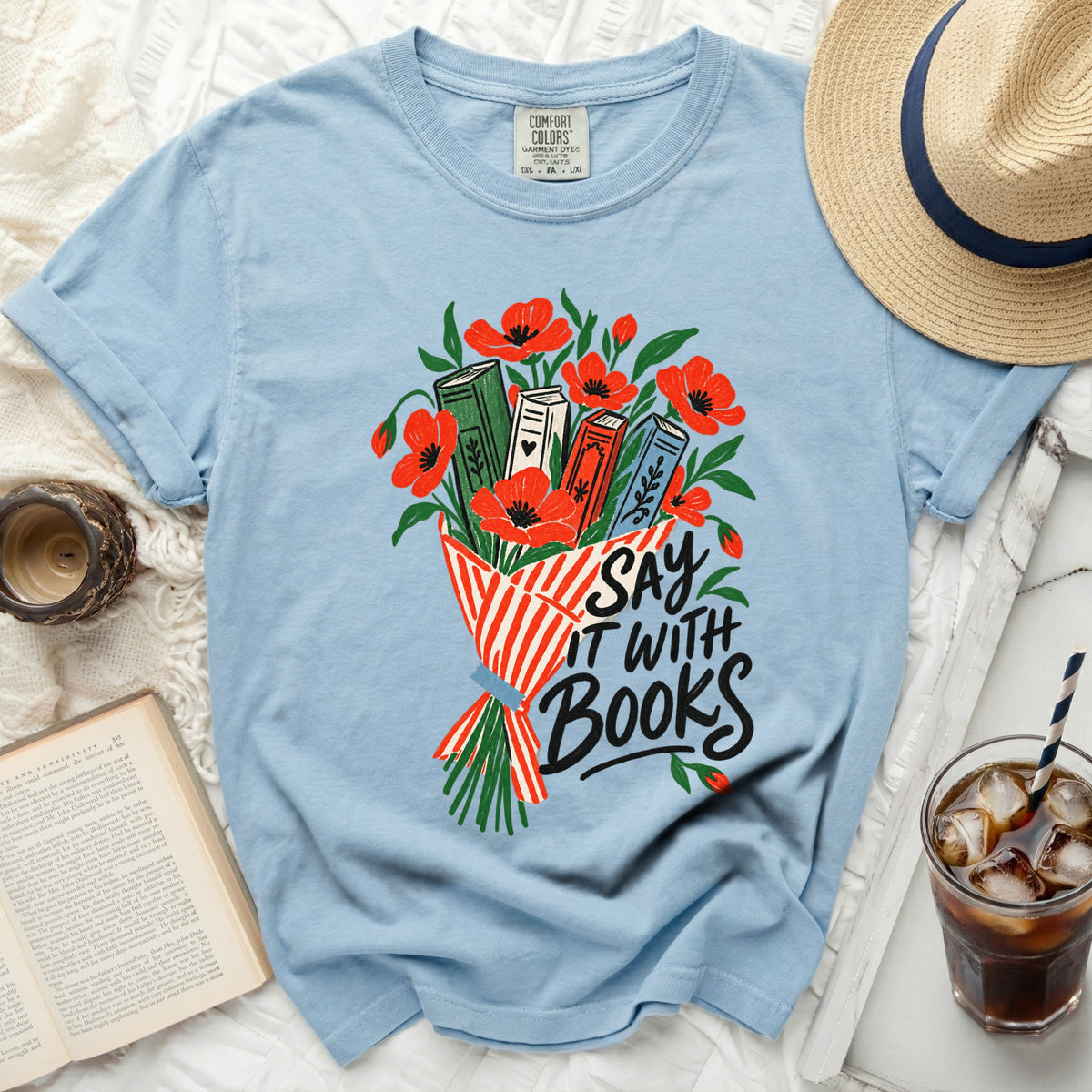Light blue t-shirt with a bouquet of books and poppies graphic and "Say It With Books" text.