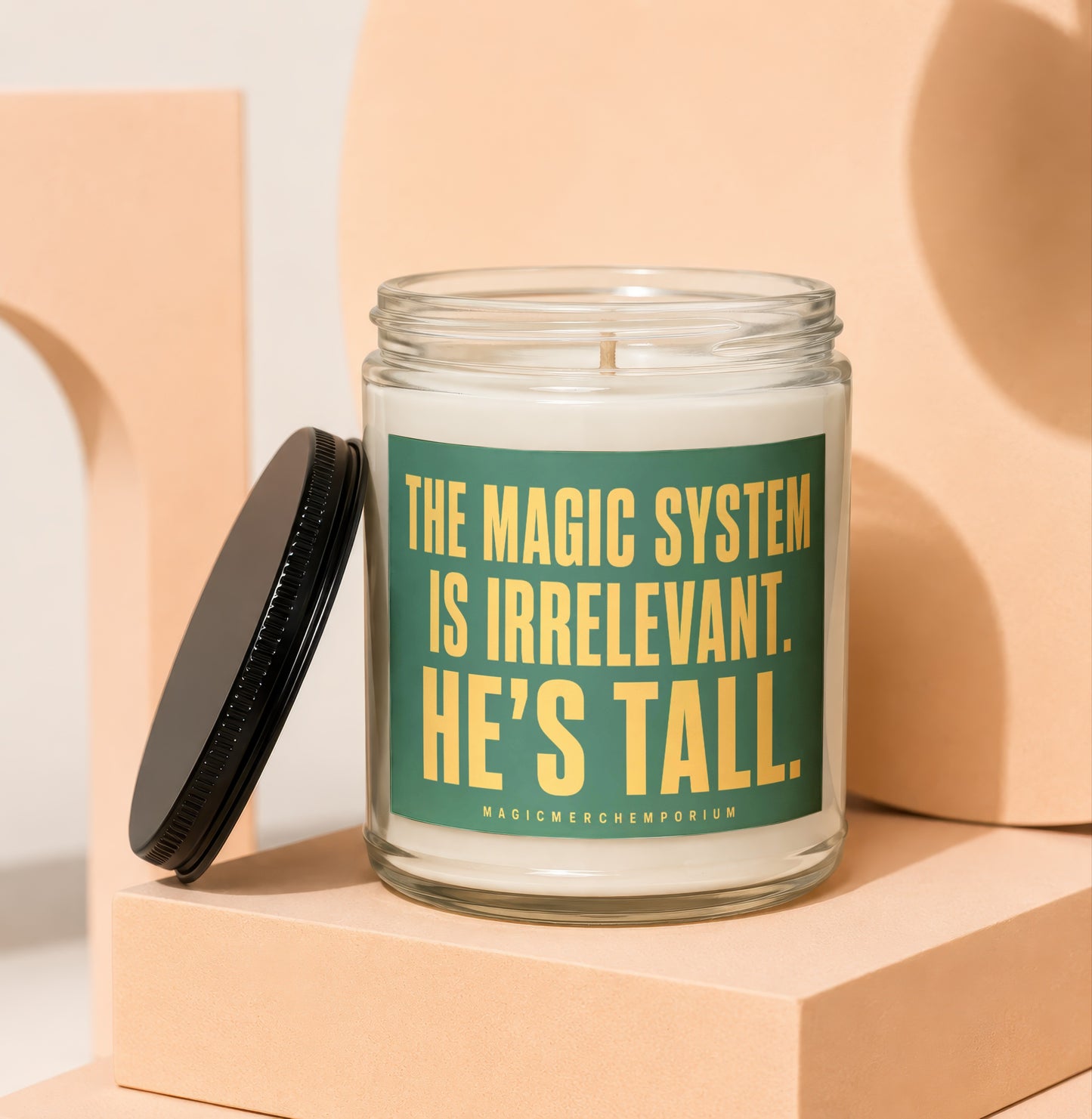 Glass candle with green label reading "The magic system is irrelevant. He's tall."