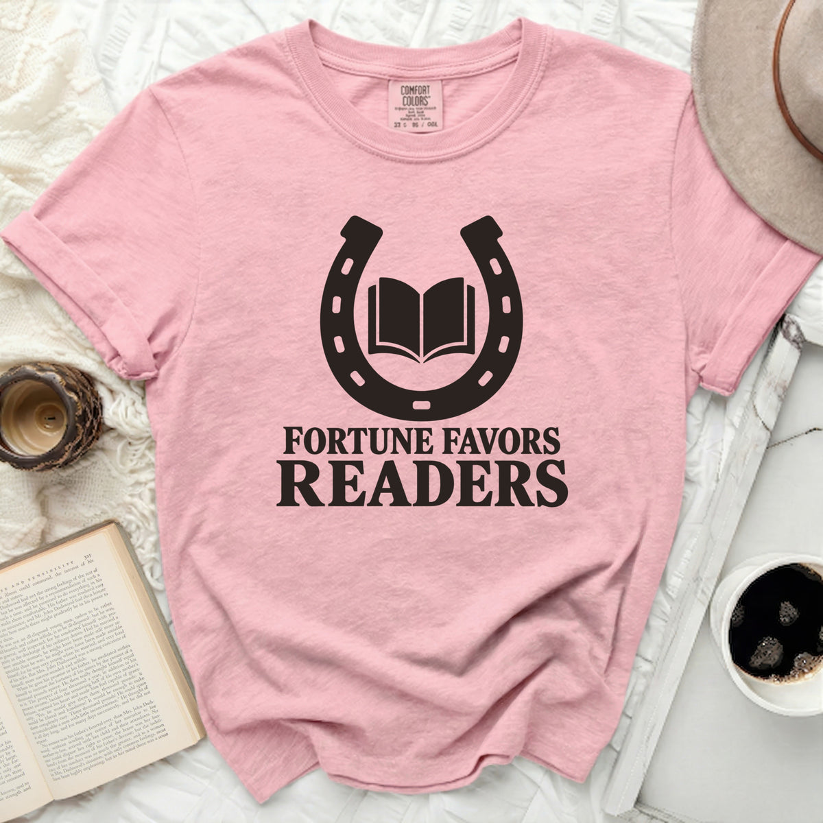 Pink t-shirt with a horseshoe and open book graphic and text "Fortune Favors Readers".
