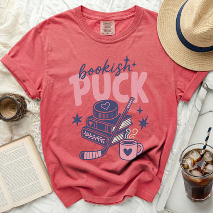Pink t-shirt with "bookish+ PUCK" text, hockey stick, books, and stars.