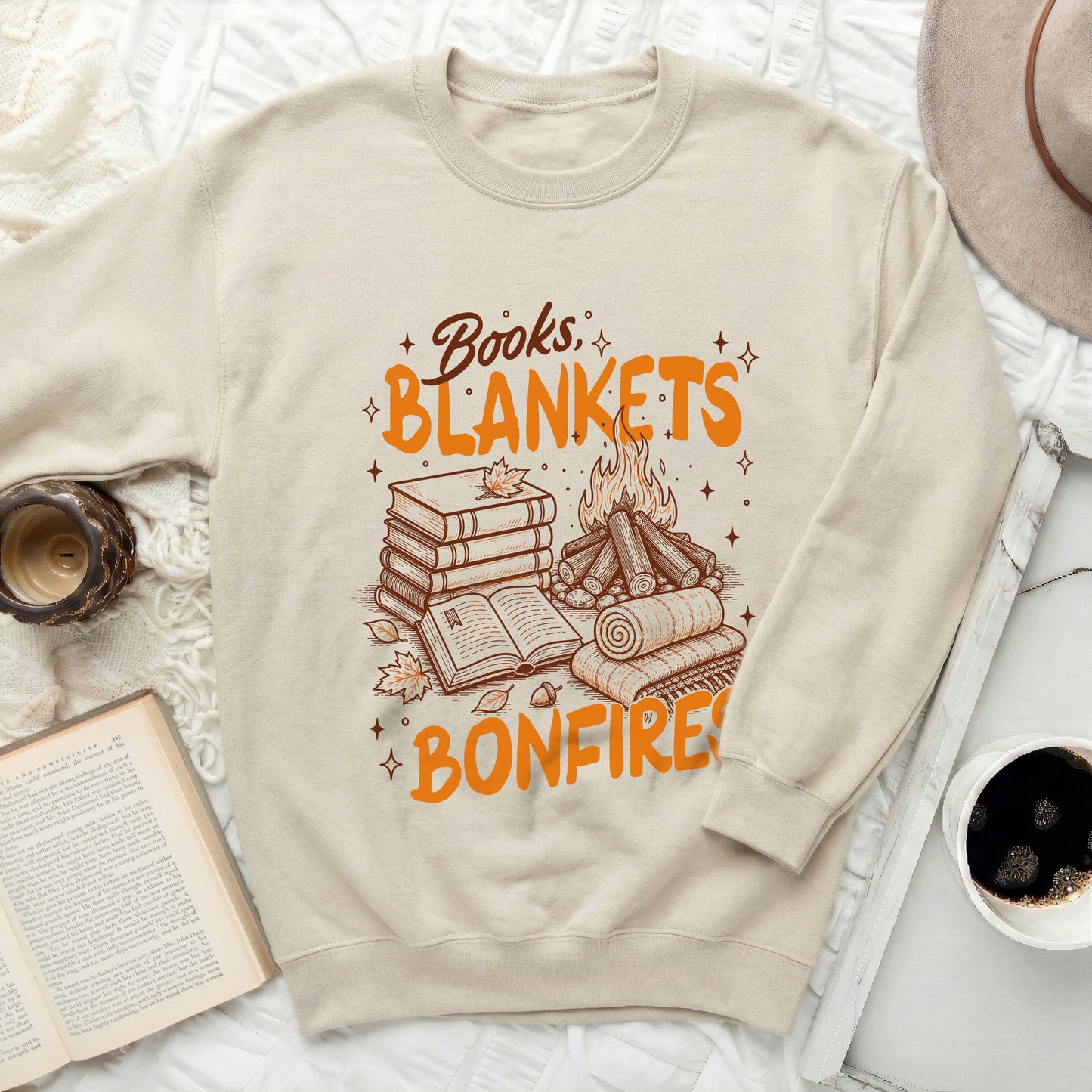 Crewneck sweatshirt with "Books, Blankets, Bonfires" and fall imagery.
