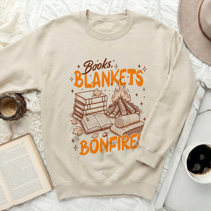 Crewneck sweatshirt with "Books, Blankets, Bonfires" and fall imagery.