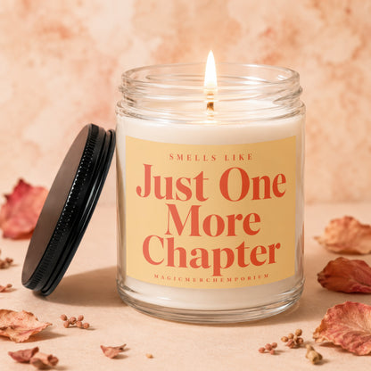 Jar candle with lit wick and label reading "Smells Like Just One More Chapter".