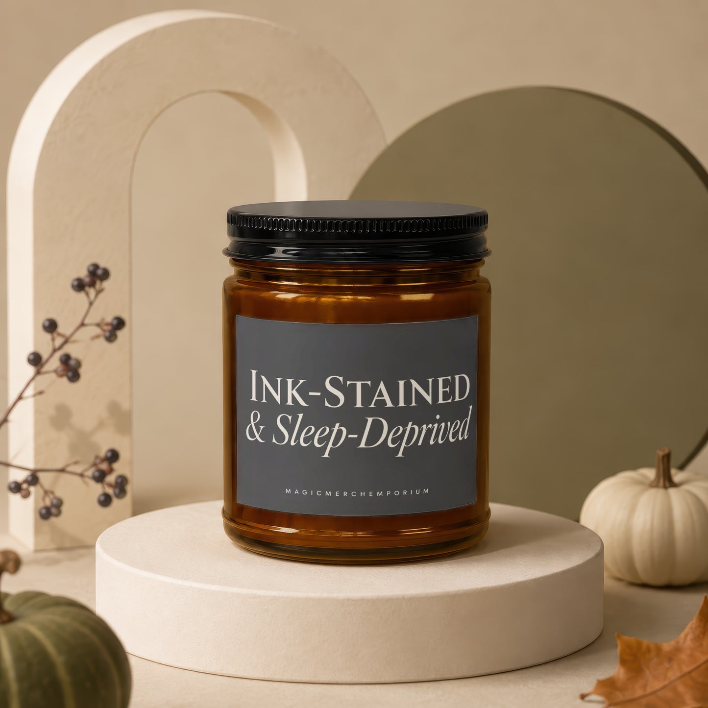 Amber jar candle labeled "INK-STAINED & Sleep-Deprived" with a dark lid.