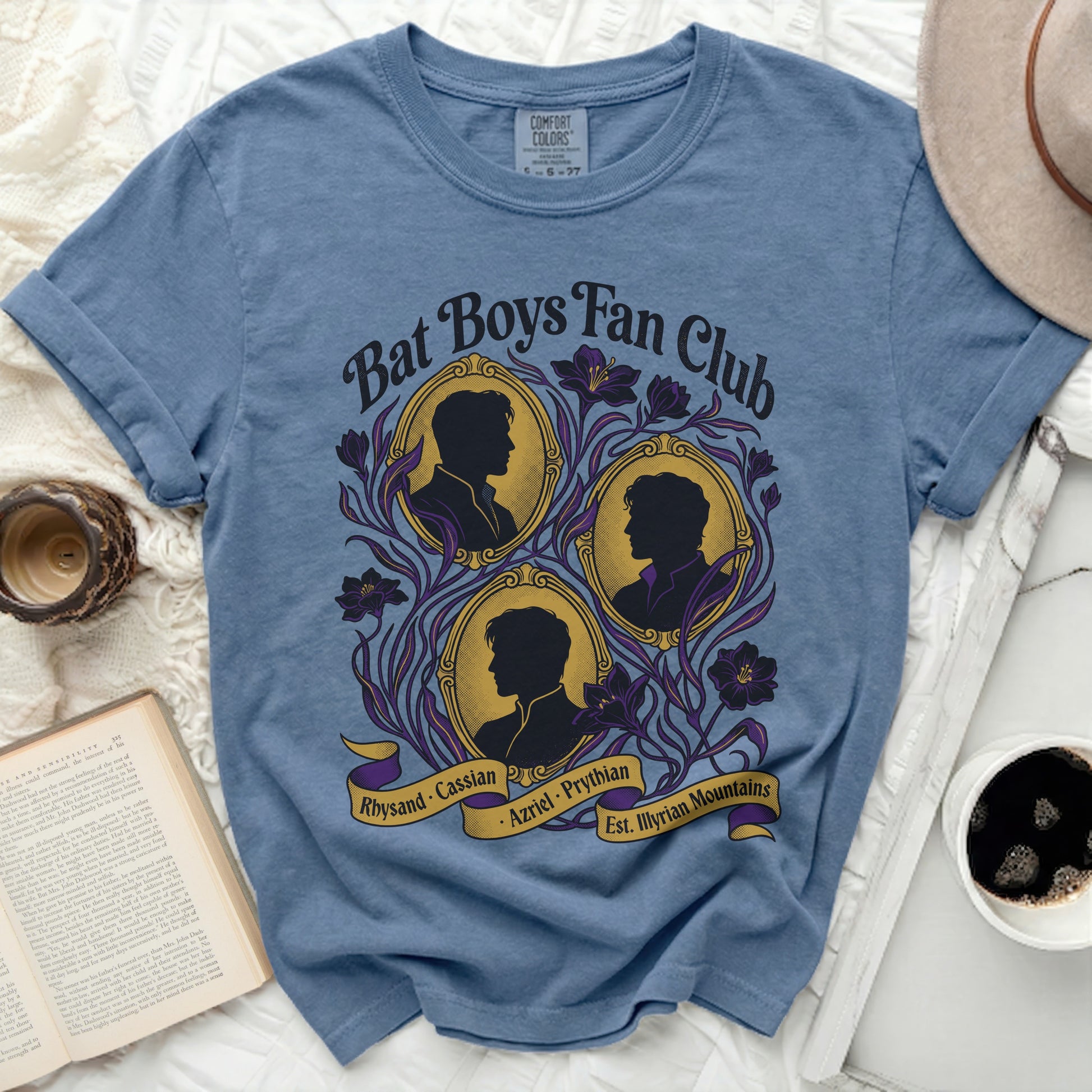 Blue t-shirt with Bat Boys Fan Club design featuring three silhouettes and floral accents.