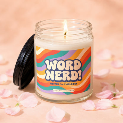 Lit glass candle with colorful "WORD NERD! WRITER ON THE LOOSE" label and black lid.