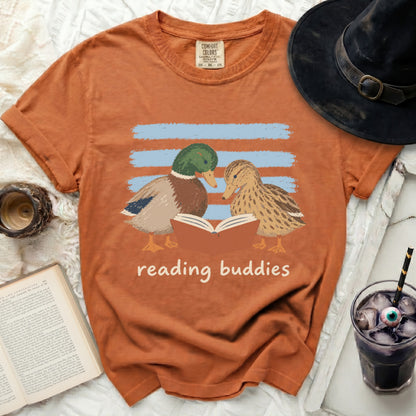 Two ducks read a book together with blue stripes behind them.