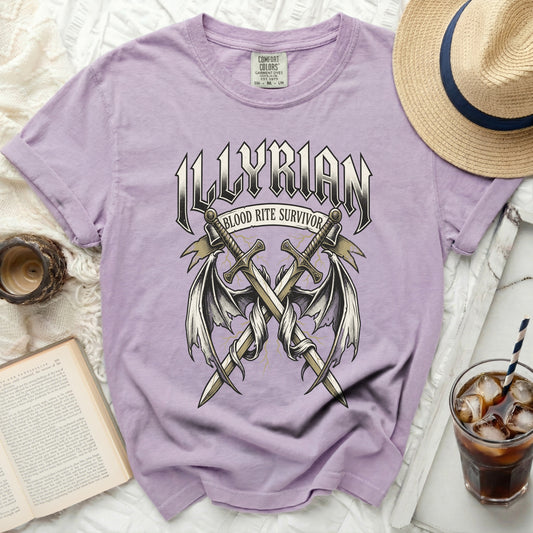Lilac t-shirt with "ILLYRIAN BLOOD RITE SURVIVOR" text and crossed swords with wings design.