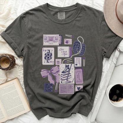 T-shirt with purple illustrations of playing cards, books, and hockey elements.