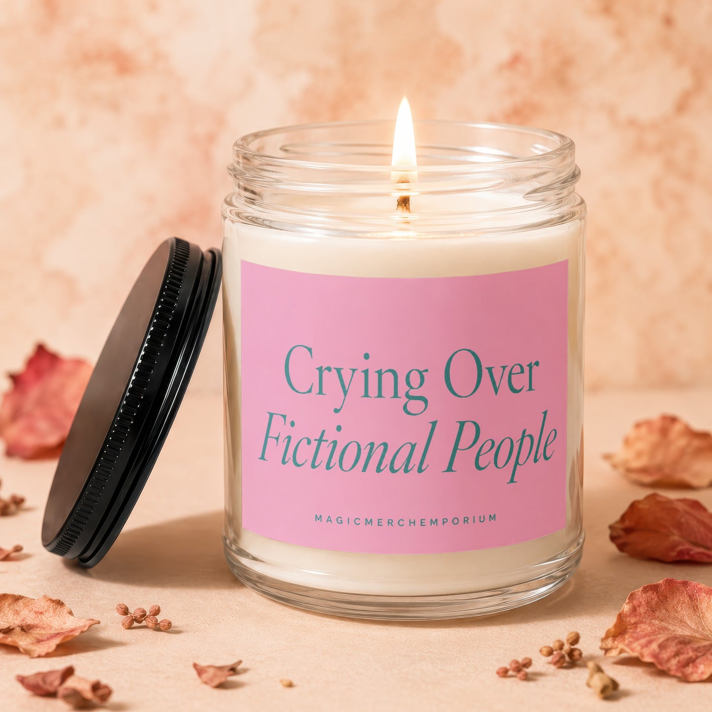 Candle with pink label reading "Crying Over Fictional People".