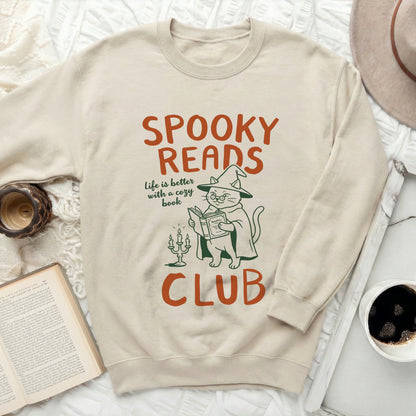Cream sweatshirt with "Spooky Reads" cat illustration and text.