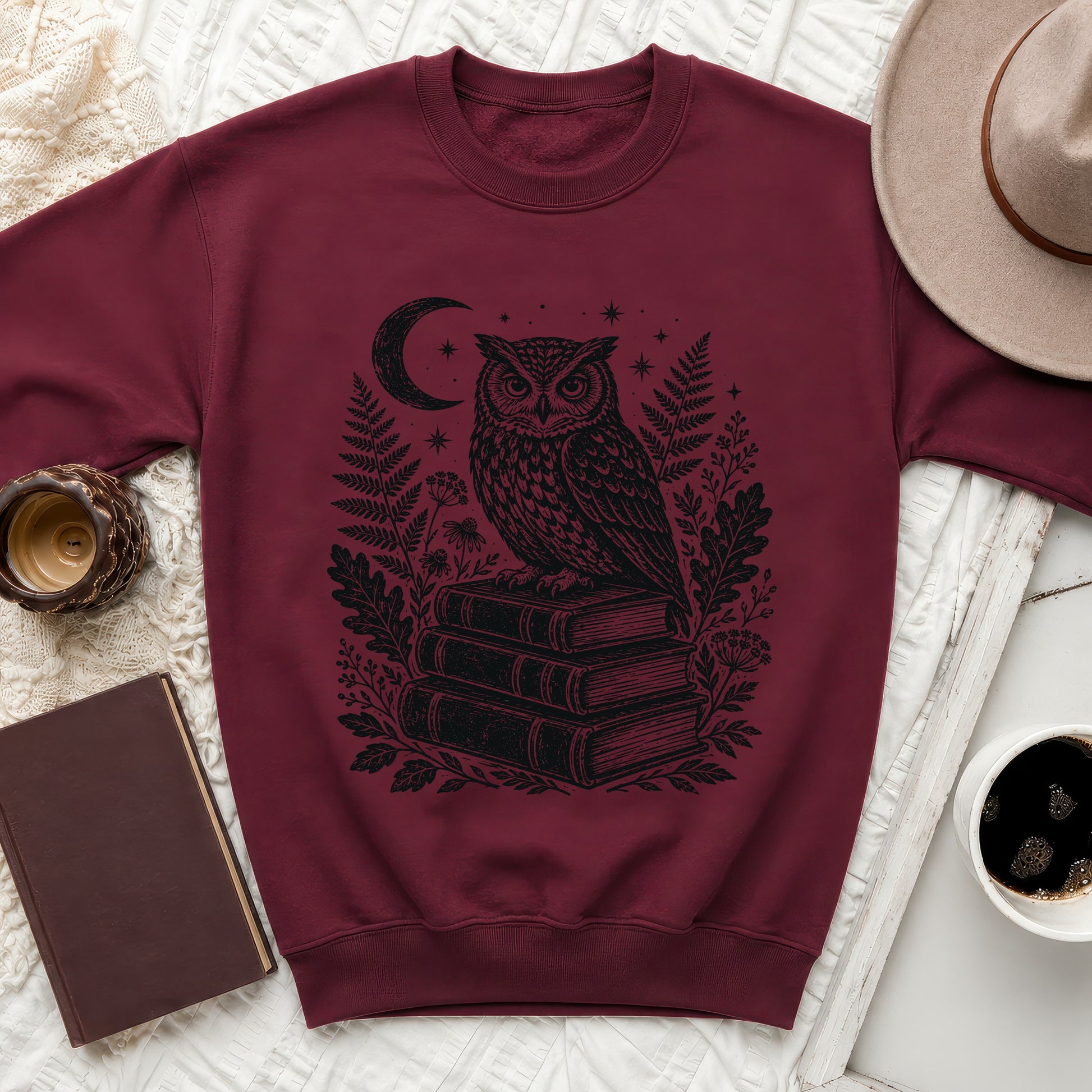 Maroon sweatshirt with a black ink drawing of an owl on stacked books.