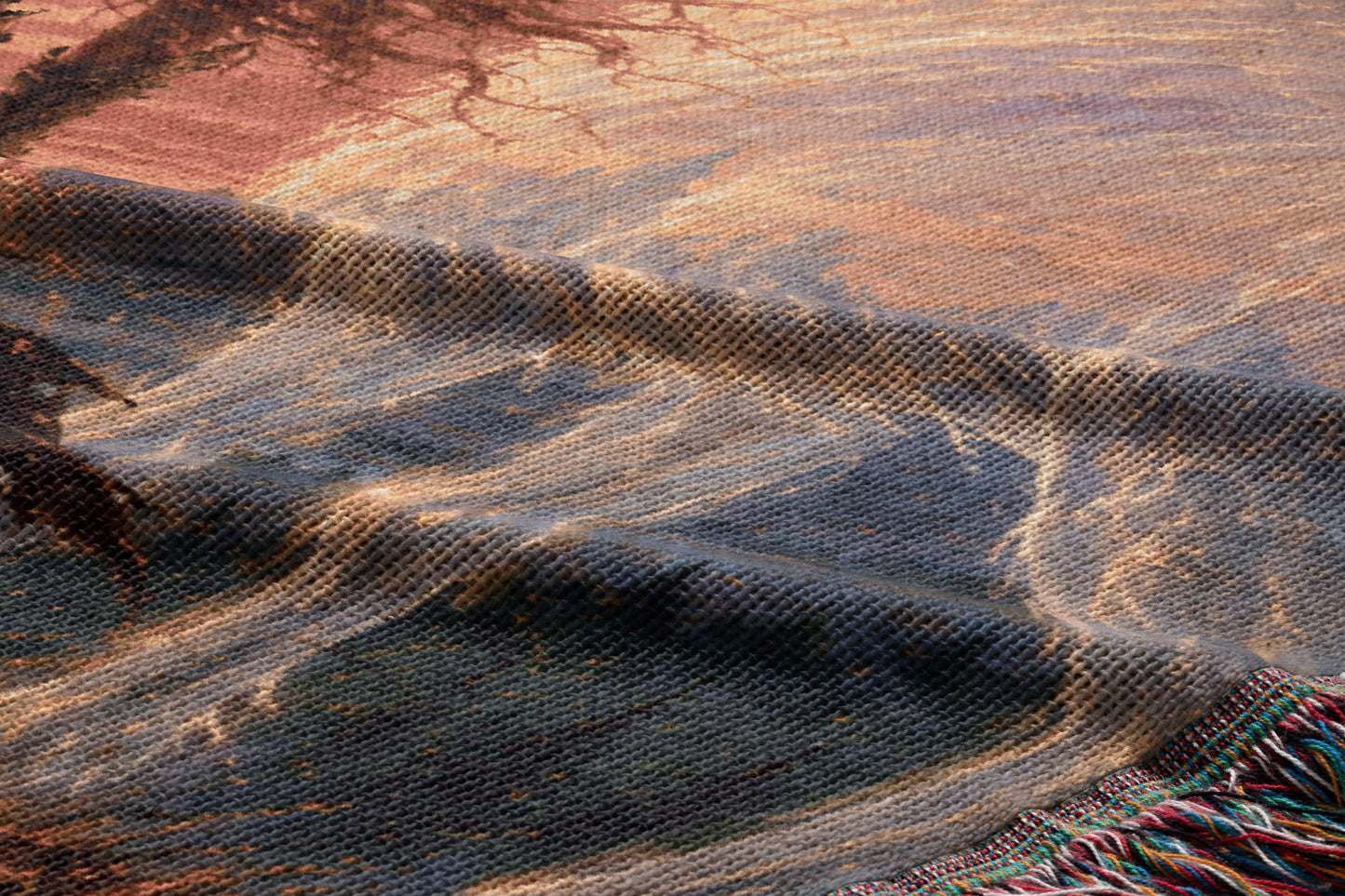 The image is a close-up of a textured fabric with a pattern of blue, orange, and brown colors. The fabric appears to be made of wool or a similar material, and it has a slightly wrinkled and folded appearance.