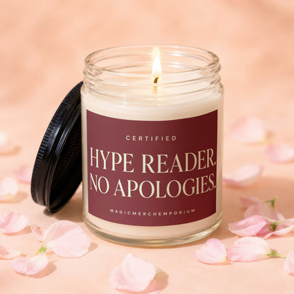 Glass candle with lit wick, black lid, and maroon label reading "Certified Hype Reader. No Apologies."