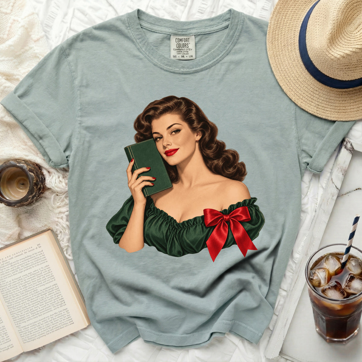 Light blue t-shirt with vintage woman illustration holding book and red bow.