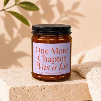 Amber candle with black lid and label reading "One More Chapter Was a Lie".