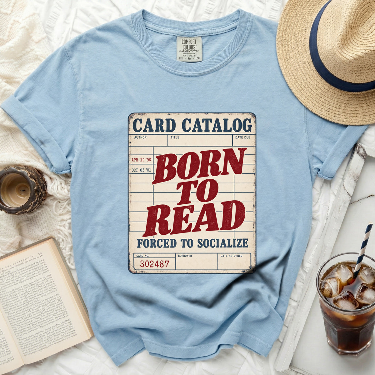 Light blue t-shirt with "Born to Read Forced to Socialize" text on a card catalog graphic.