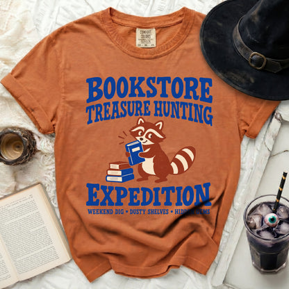 Orange t-shirt with "Bookstore Treasure Hunting Expedition" and a raccoon.