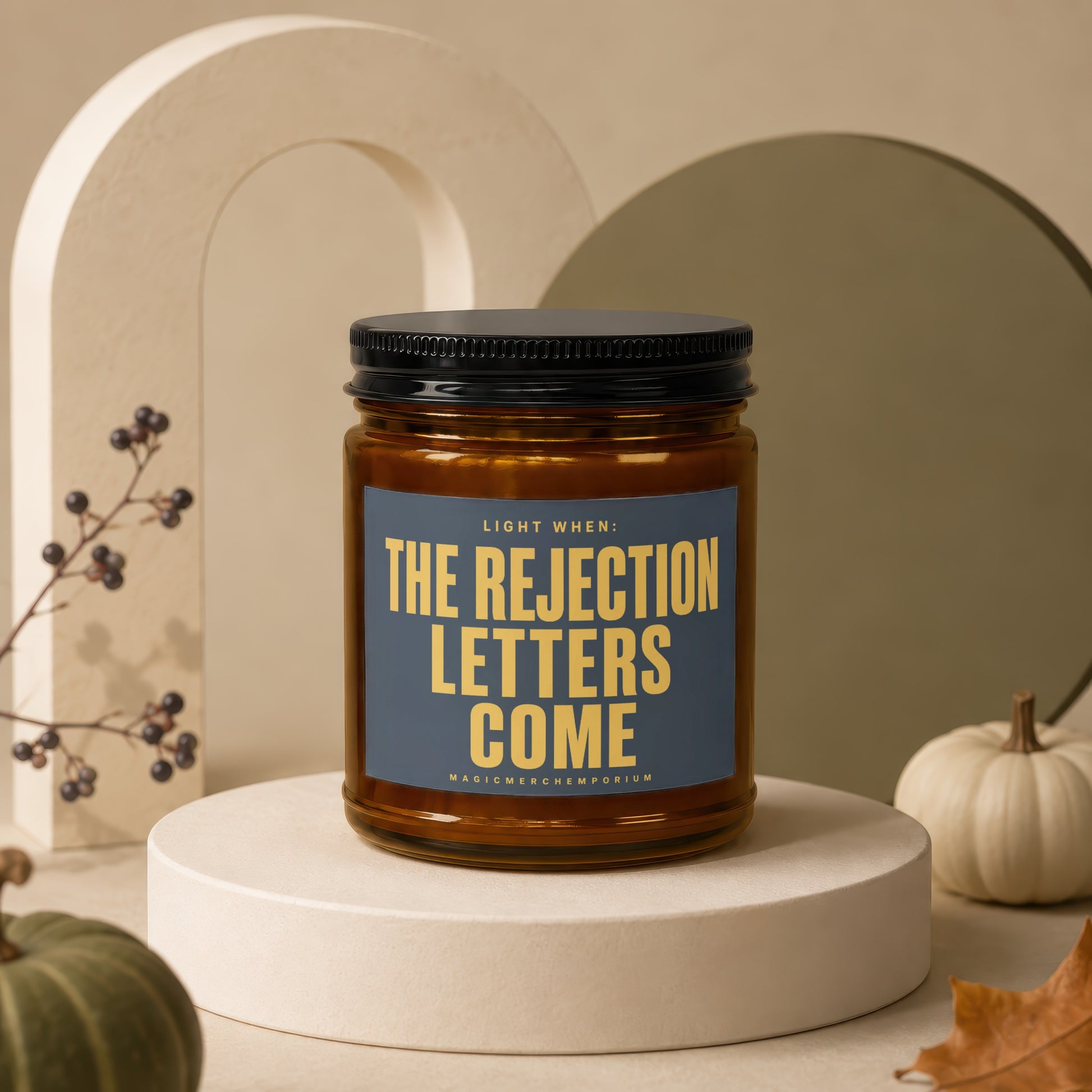 Amber jar candle with black lid, reading "Light When: The Rejection Letters Come".