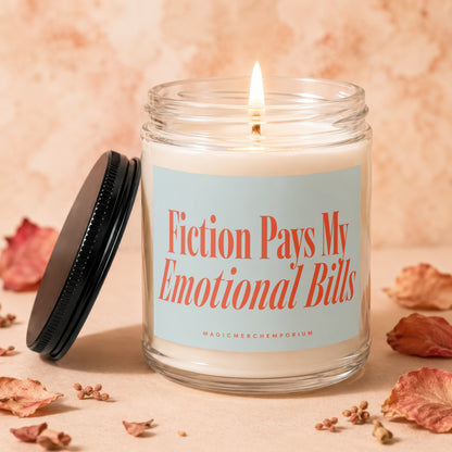Jar candle with a lit wick and the text "Fiction Pays My Emotional Bills"