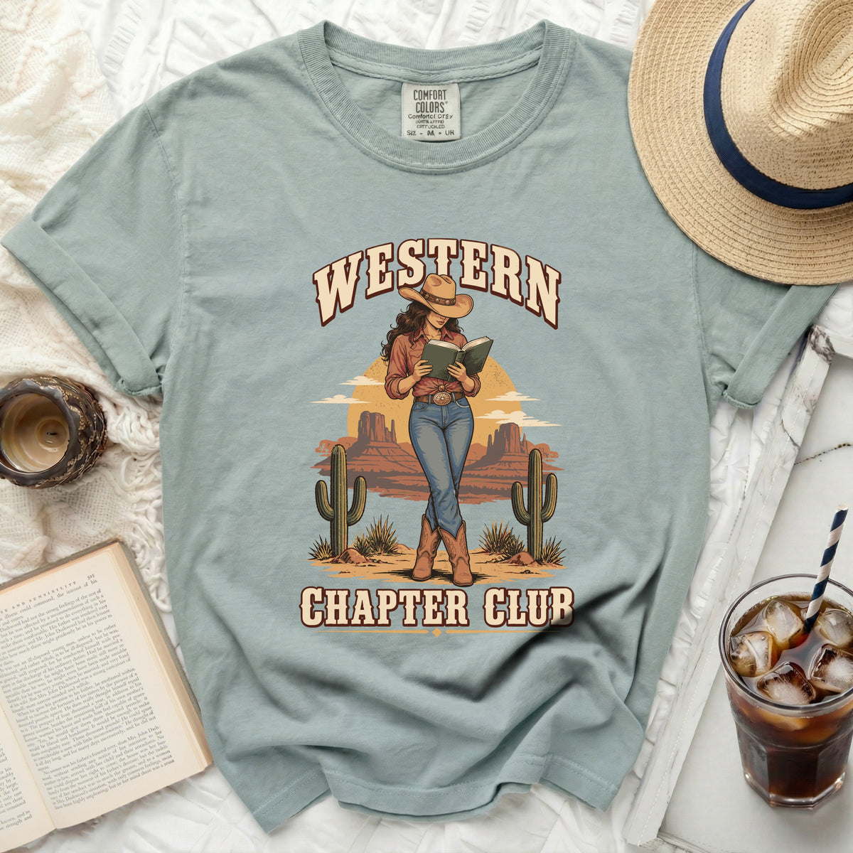 T-shirt graphic features "Western Chapter Club" with a cowboy reading in a desert landscape.