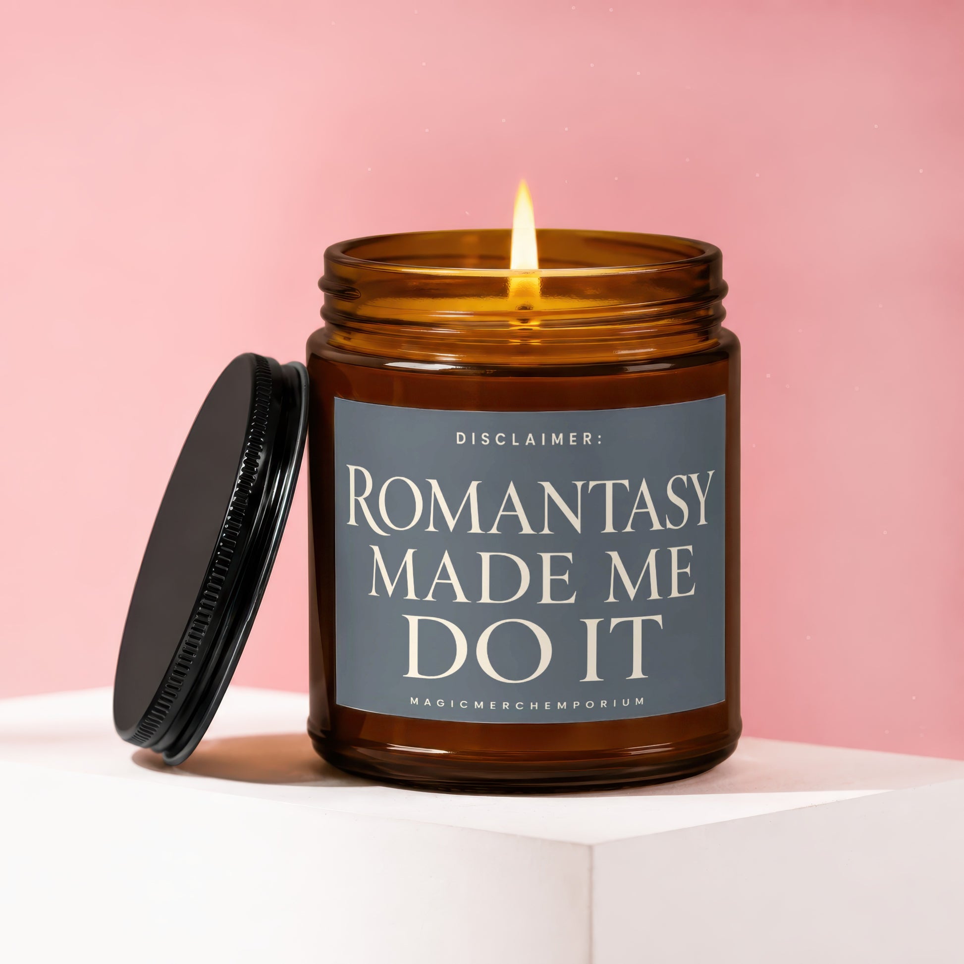 Lit amber glass candle with black lid and label reading: Disclaimer: Romantasy Made Me Do It