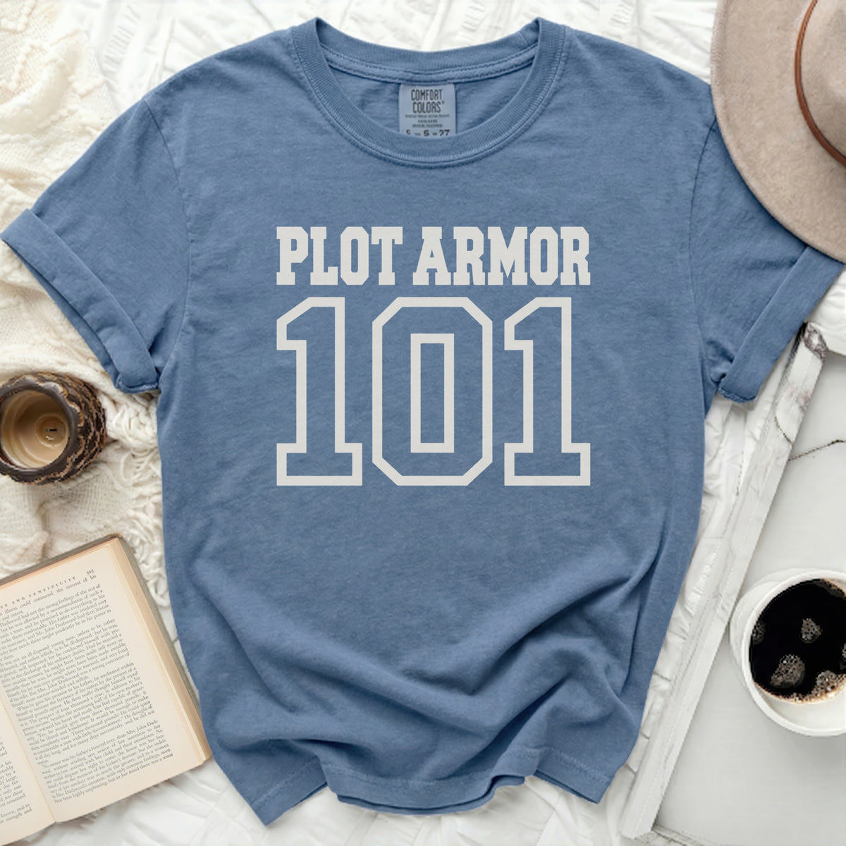 Blue t-shirt with "PLOT ARMOR 101" printed in white block letters.
