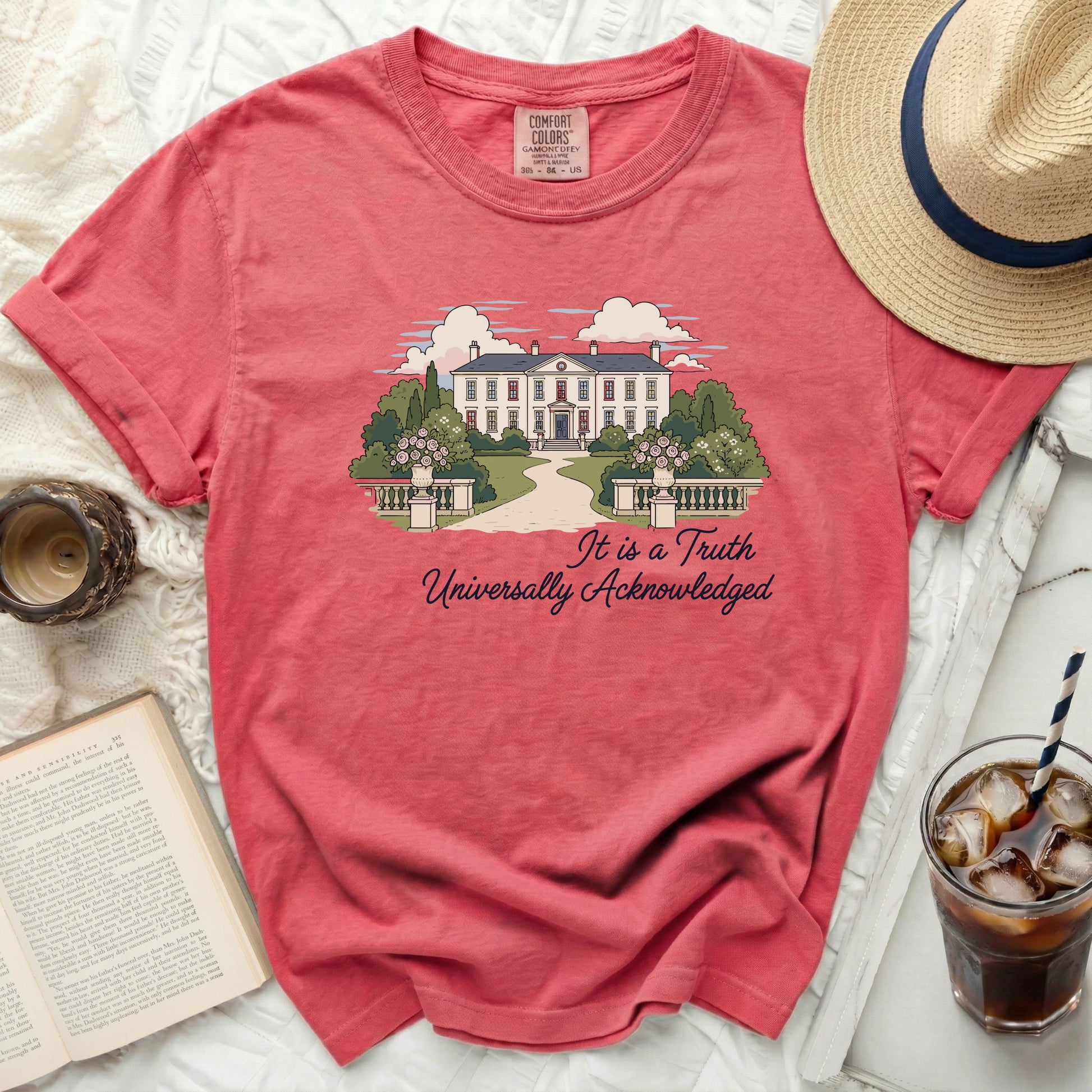 Coral t-shirt with illustration of a grand house and text "It is a Truth Universally Acknowledged".